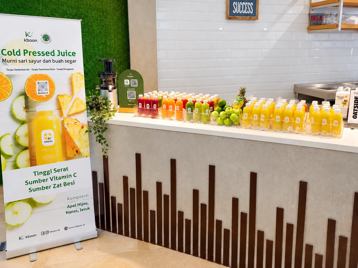 Booth Kboon Cold Pressed Juice di sebuah acara kantor, lengkap dengan banner dan deretan botol