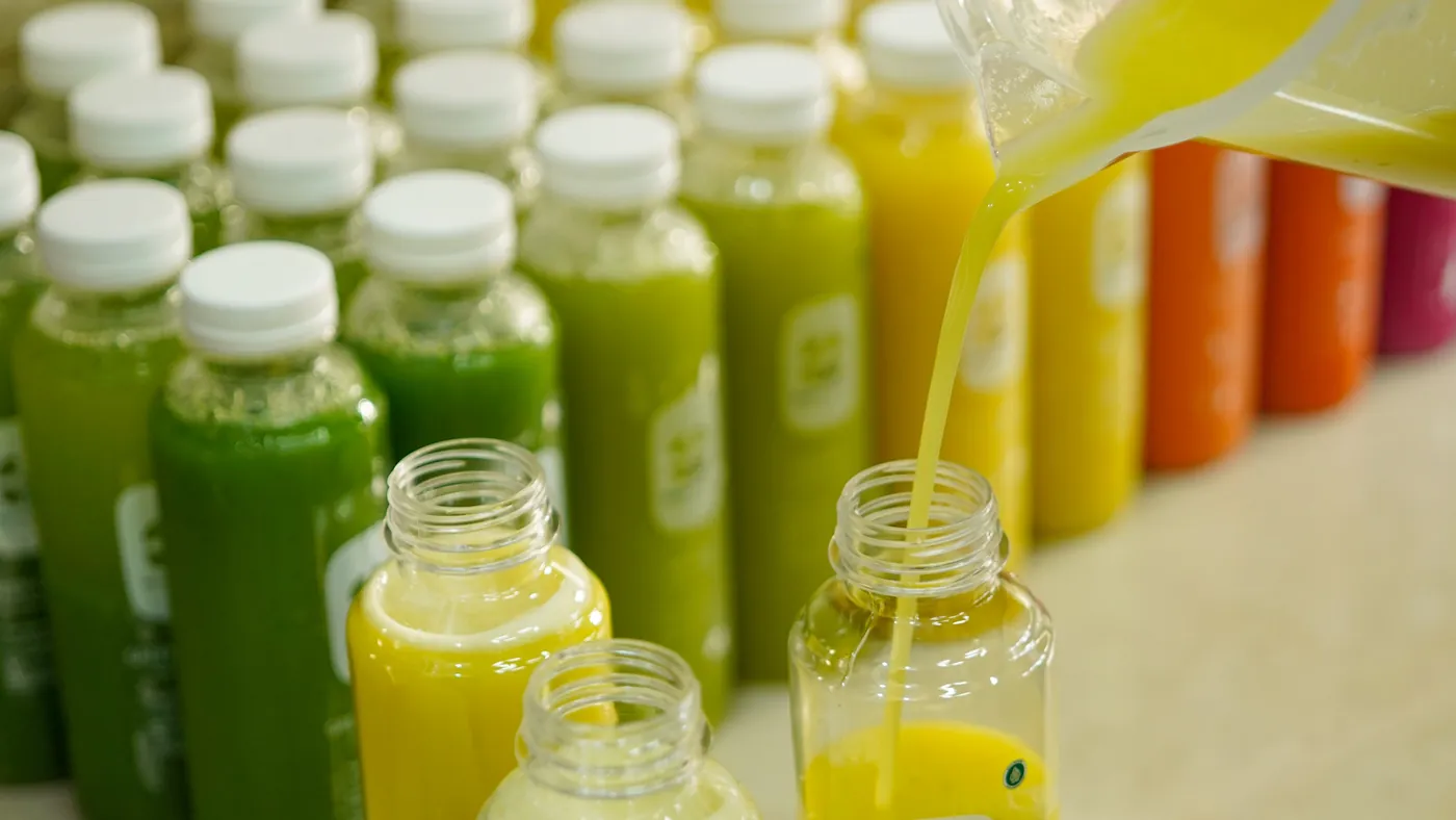 Jus segar dituang ke deretan botol Kboon untuk pesanan acara